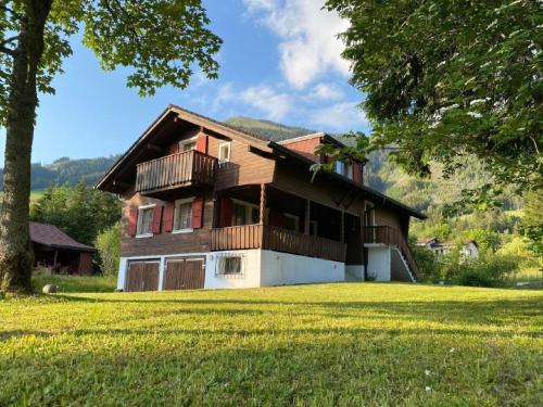 a house with a balcony and a yard at Apartment Chalet Bacchus - EG by Interhome in Sörenberg