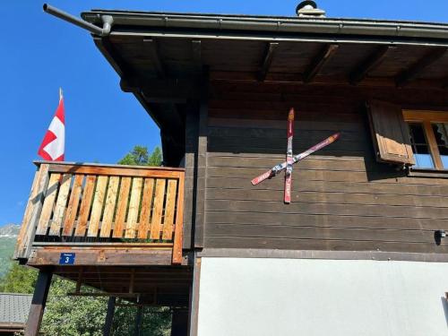 a clock on the side of a building with a flag at Holiday Home Chalet Glücksfall by Interhome in Bellwald