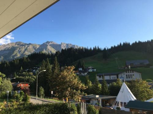 a view of a town with a white tent and mountains at Apartment Lauigrund by Interhome in Sörenberg