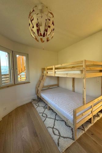 a bedroom with bunk beds and a chandelier at Apartment Sonnehüsli by Interhome in Flühli