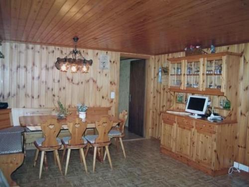 a dining room with a table with chairs and a computer at Apartment Fruehalp by Interhome in Unterägeri