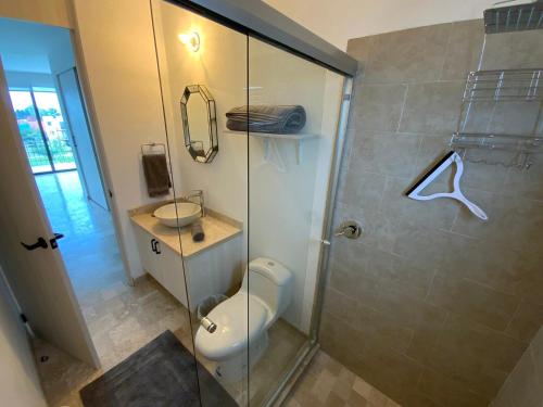 a bathroom with a toilet and a glass shower at LUMINARIA Pool, Near the Historic Center | Elegant in San Miguel de Allende