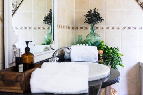 a bathroom with a sink and a mirror at Shekinah Cabin in Hartbeespoort