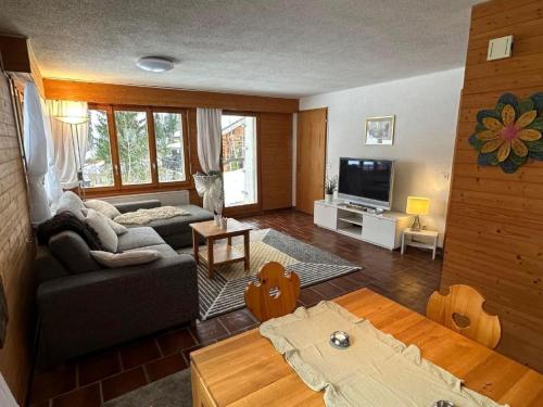 a living room with a couch and a tv at Apartment Rothornblick by Interhome in Sörenberg