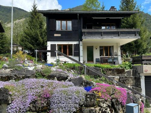 a house with a bunch of flowers in front of it at Apartment Rothornblick by Interhome in Sörenberg