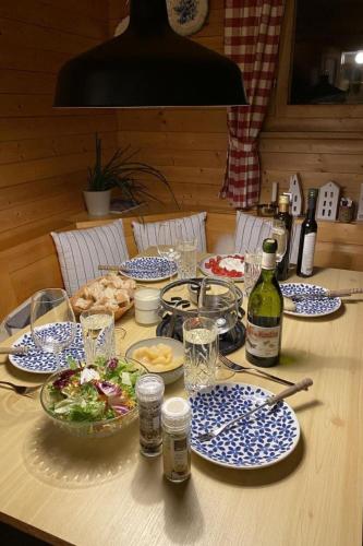 a table with blue and white plates of food and wine at Apartment Chalet Bacchus - OG by Interhome in Sörenberg