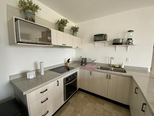 a kitchen with white cabinets and a sink at LUMINARIA Pool, Near the Historic Center | Elegant in San Miguel de Allende