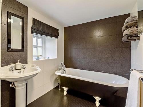 a bathroom with a sink and a bath tub and a sink at 3 Bed in Egremont oc-90050 in Hale