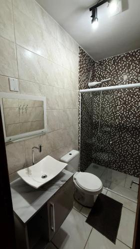 a bathroom with a toilet and a sink and a shower at Duplex completo, perto da praia e no centro de Imbé in Imbé