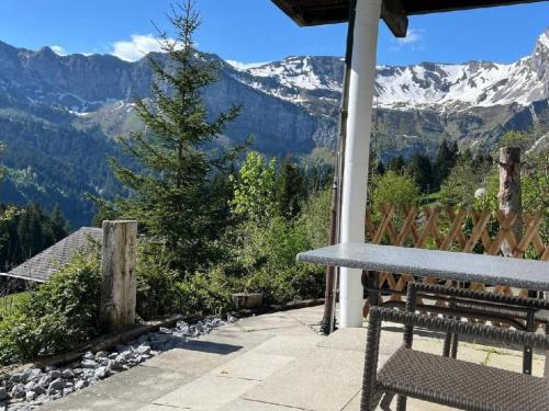 a bench sitting on a porch with a view of mountains at Apartment Chalet Hörler direkt im Ski- und Wandergebiet by Interhome in Emmetten
