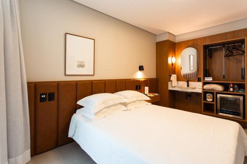 a bedroom with a white bed and a sink at Livramento Palace Hotel in Vitória da Conquista