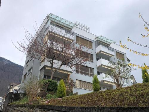 a white building with trees in front of it at Apartment Studio Rubi Weggis by Interhome in Weggis