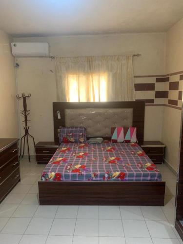 een slaapkamer met een bed in een kamer met een camera bij ARRAYAN-MAe'WA in Dakar
