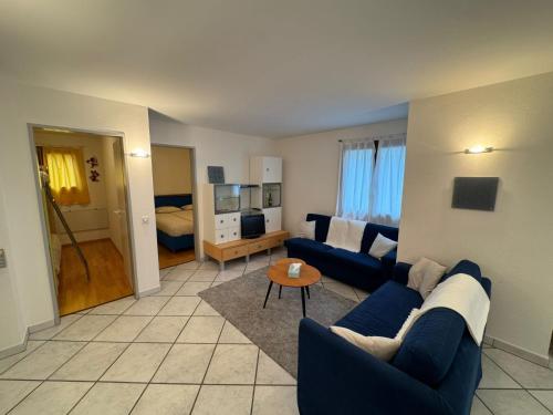 a living room with a blue couch and a table at Apartment Walserwohnung by Interhome in Bosco Gurin