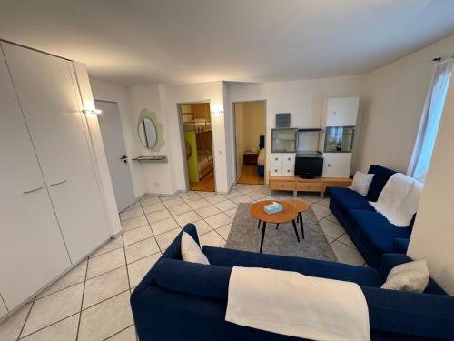 a living room with a blue couch and a table at Apartment Walserwohnung by Interhome in Bosco Gurin