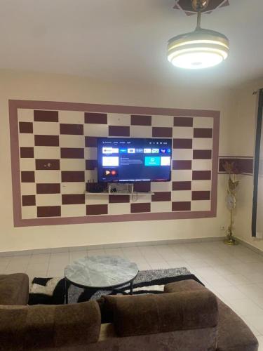 a living room with a large tv on a wall at ARRAYAN-MAe'WA in Dakar