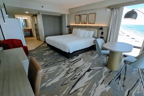 a hotel room with a bed and a table at Nautilus Inn - Daytona Beach in Daytona Beach