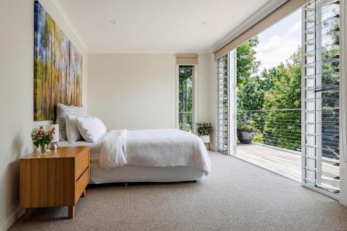 a bedroom with a bed and a large window at The Tailor's Terrace, Kangaroo Valley in Kangaroo Valley