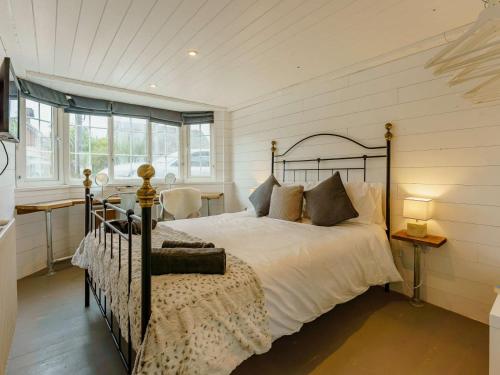 a bedroom with a bed and a desk and windows at 6 Bed in Rye- oc-89037 in Camber