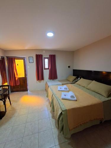 a hotel room with two beds and a table at Hosteria Marina Bella 3 in Rada Tilly