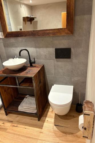 a bathroom with a sink and a toilet and a mirror at Apartment Poste viglia by Interhome in Lohn