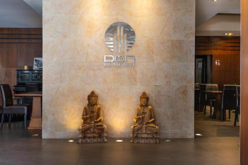 two statues of two people sitting in front of a wall at DON Boutique Hotel Montevideo in Montevideo
