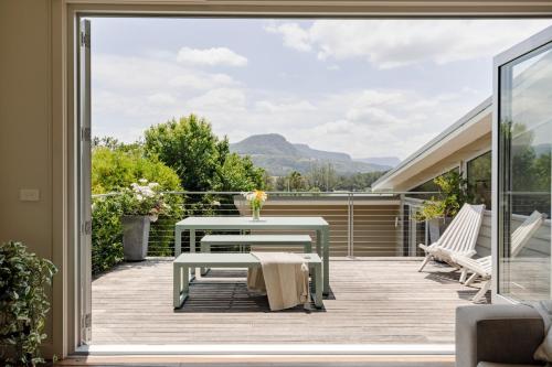 a patio with a table and chairs on a deck at The Tailor's Terrace, Kangaroo Valley in Kangaroo Valley