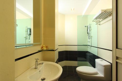 uma casa de banho com um lavatório, um WC e um espelho. em Seasons View Hotel em Kuantan