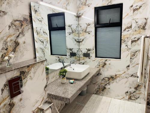 a bathroom with a sink and two windows at Legacy Dreams in Islamabad