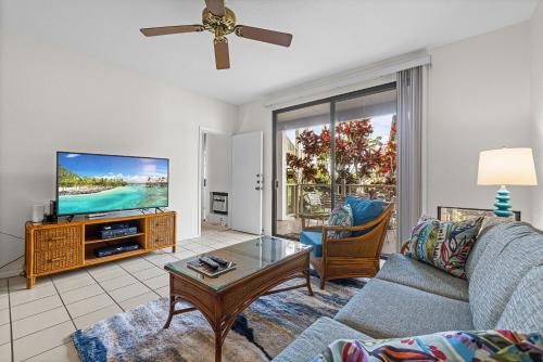 a living room with a couch and a tv at Grand Champions 033 in Wailea