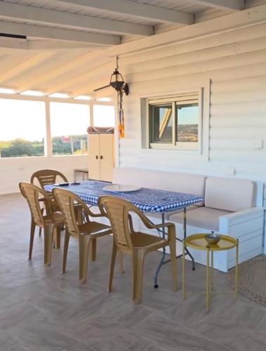 a dining room with a table and chairs and a couch at New view in Majdal Shams