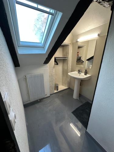 a bathroom with a sink and a window at Duplex au cœur de la Bastide in Villefranche-de-Rouergue