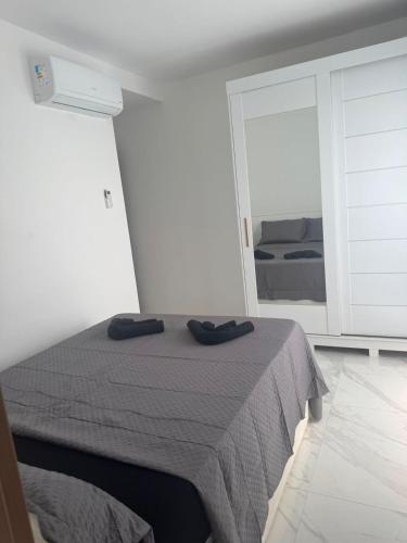 a bedroom with a bed with two black shoes on it at Apartamento del sole in Vitória