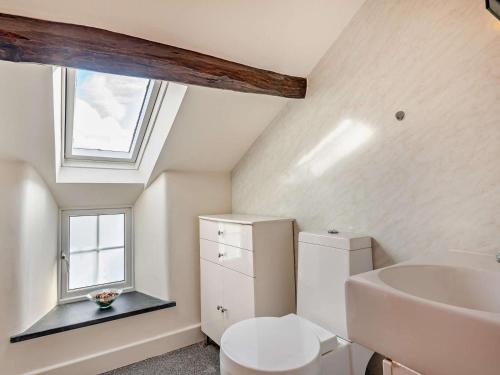 a bathroom with a toilet and a sink and a window at 3 Bed in Keswick oc-94346 in Threlkeld