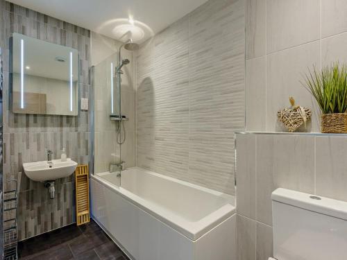 a bathroom with a bath tub and a sink at 2 Bed in Sandown oc-89291 in Sandown