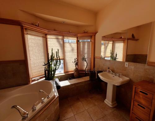 a large bathroom with a tub and a sink at Le Domek de nature apaisante in Sainte Béatrix