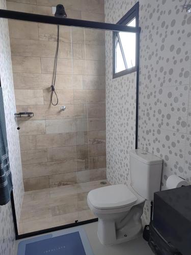 a bathroom with a toilet and a shower at Refúgio 4 Praia Indaiá Bertioga 150 mts da praia in Bertioga