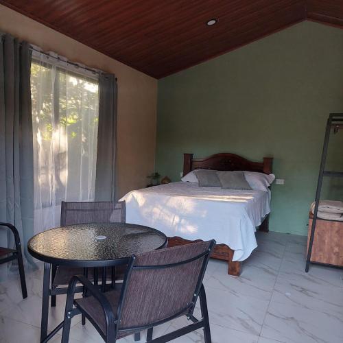 a bedroom with a bed and a table and chairs at Green Trails Miravalles in Bagaces
