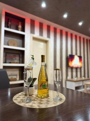 a bottle of wine and two glasses on a table at Perisic Apartman Obrenovac, sa parkingom in Obrenovac