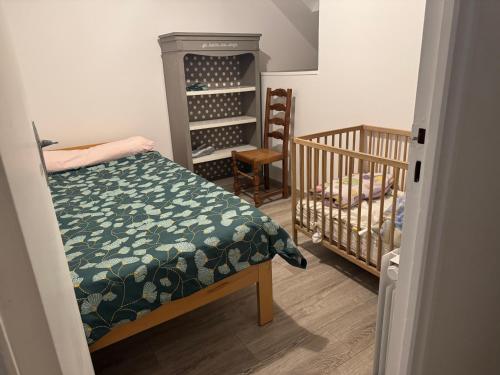 Duplex appartement في إتامب: غرفة نوم بها سرير وسرير أطفال ورف نبيذ