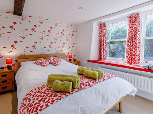 a bedroom with a bed with red and white pillows at 3 Bed in Baslow oc-pk917 in Baslow