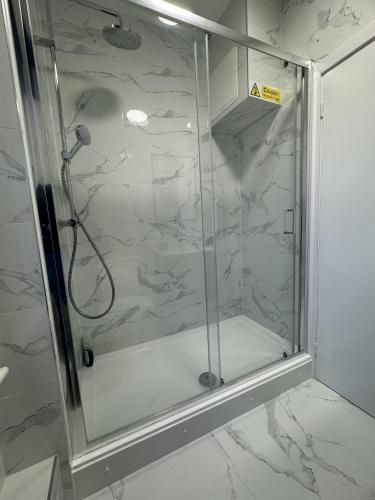 a shower with a glass door in a bathroom at New Kings Cross Comfort in London