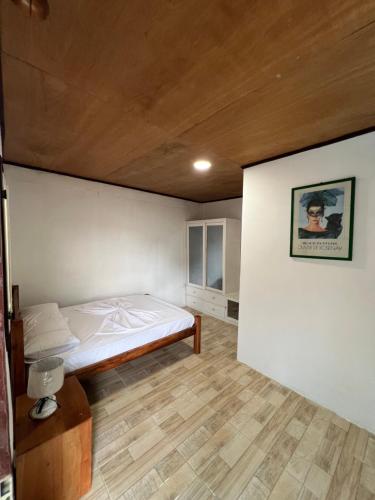 a bedroom with a bed and a wooden ceiling at Resort Ideal Forest in São Tomé