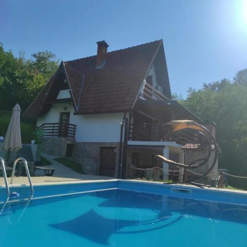 a house with a swimming pool in front of a house at Vikendica Popovic in Doboj