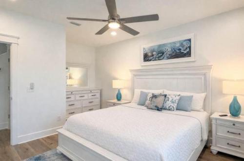 a white bedroom with a bed and a ceiling fan at New- Prime Location - Ground Floor Bedroom - Pool in Eastpoint