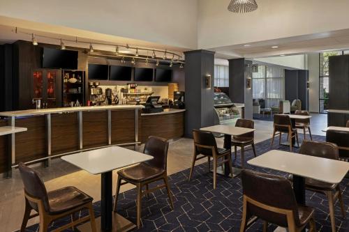 a restaurant with tables and chairs and a bar at Courtyard by Marriott Sacramento Midtown in Sacramento