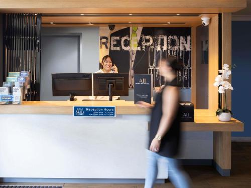 a woman standing in front of a hair salon at ibis Budget Brisbane Airport in Brisbane
