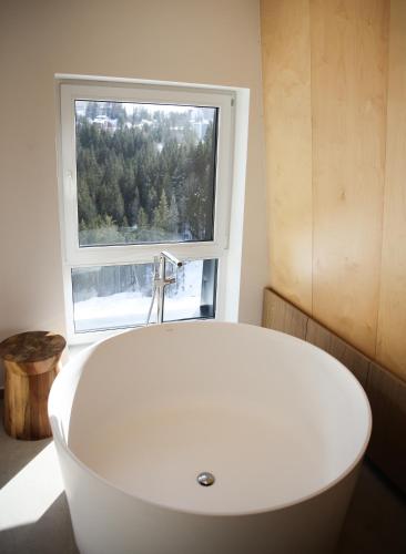 a white bath tub in a bathroom with a window at A63 Premium apartment located in hotel Vucko-private host in Jahorina