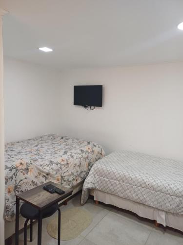 a bedroom with two beds and a tv on the wall at Tomy in Río Grande