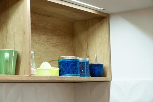 a cupboard with blue cups and other items on it at Grin Apartments in San Rafael